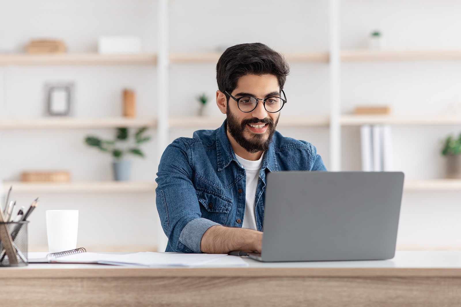 happy freelance man working from laptop smiling